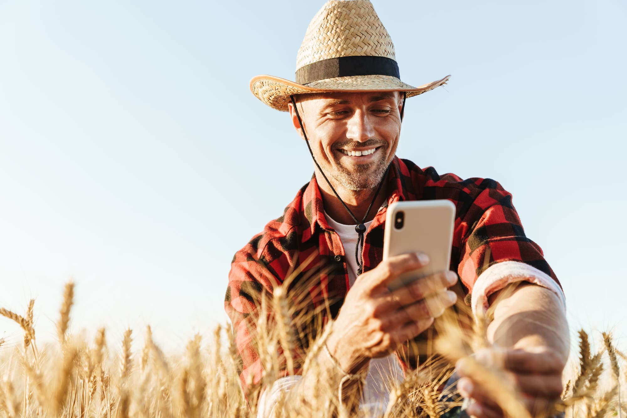 Contacta amb nosaltres Imatge d'un agricultor mirant el mòbil.